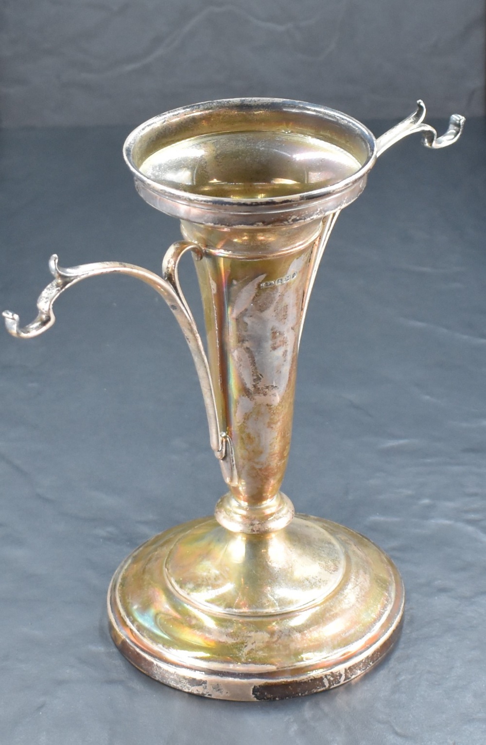 A George V silver epergne, of moulded and tapering cylindrical form flanked by sinuous brackets (