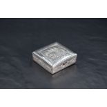 A Cambodian 900 grade white metal travelling ashtray, of hinged square form with embossed temple