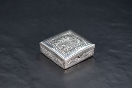 A Cambodian 900 grade white metal travelling ashtray, of hinged square form with embossed temple