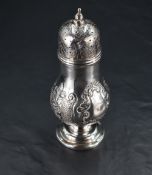 A Victorian silver sugar caster, having a pierced, finial topped and engraved cover over the foliate