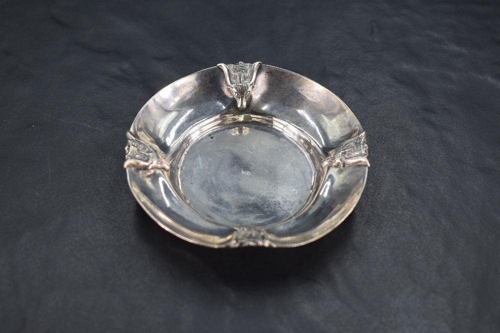 An interesting 900 grade white metal pin dish, the rim embossed with stylised rams head and axe