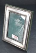 A white metal mounted photograph frame, of rectangular form with reed and ribbon moulded border,