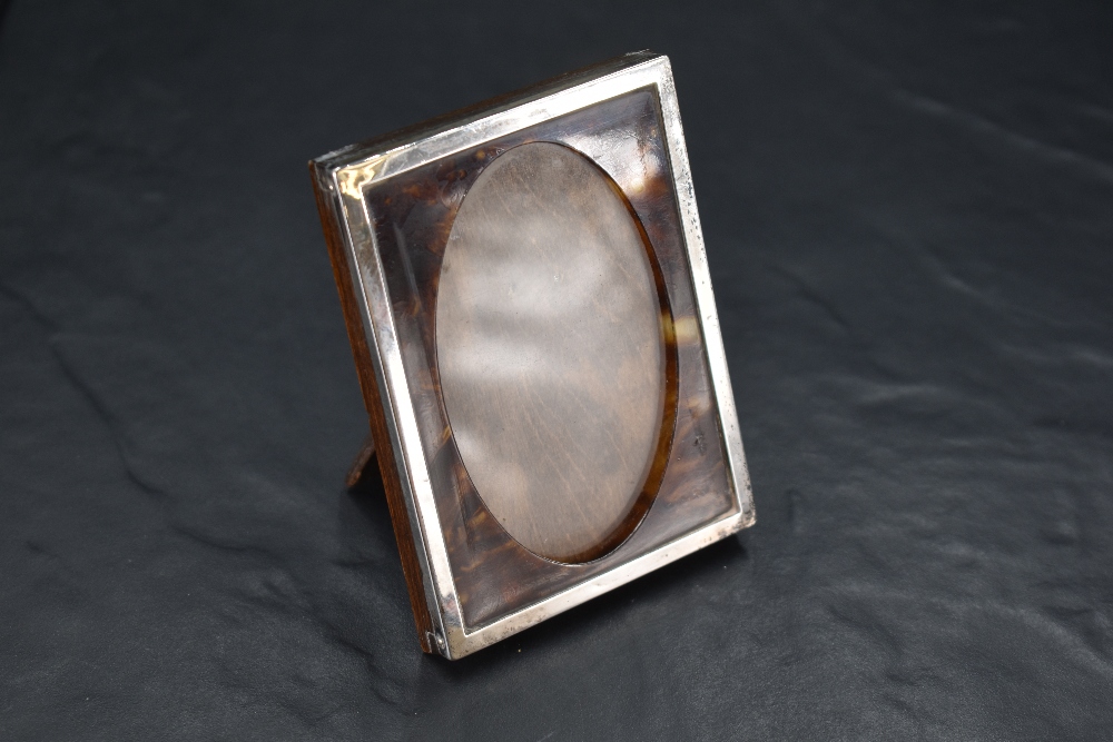 A small George V silver and tortoiseshell photograph frame, the interior with oval aperture, marks