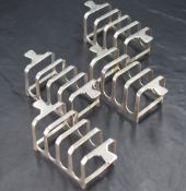 A group of four Art Deco design silver four division toast racks, each of rectangular form with