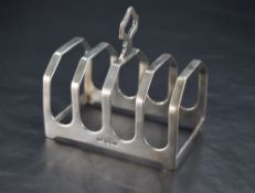 A George V silver four-division toast rack, with central shaped and pierced central handle, marks