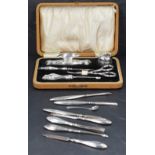 A George V silver mounted and cased manicure set, with embossed foliate decoration to the mounts,