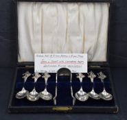 A cased set of silver teaspoons and matching sugar tongs, each with twisted stems and figural