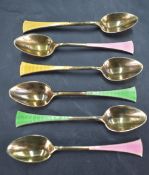 A group of six 1930's silver gilt and enamel coffee spoons, the splayed terminals engine-turned