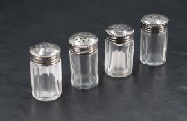 A group of four continental white metal topped clear glass condiments, of octagonal cut
