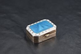 An attractive George V silver and guilloche enamel pill box, of canted and hinged rectangular form