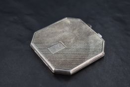A George VI silver powder compact, of canted and hinged square form with engine-turned decoration,
