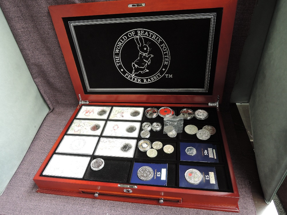 A Danbury Mint wooden cased part set containing six Beatrix Potter 50p Coins in plastic cases or