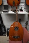 A traditional guitar lute having six strings and scalloped finger board, with carved figure head and