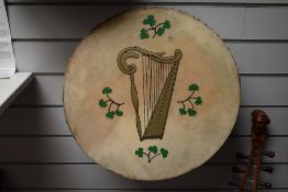 A traditional bodhran drum , with Celtic harp and clover design to skin, diameter approx. 45cm