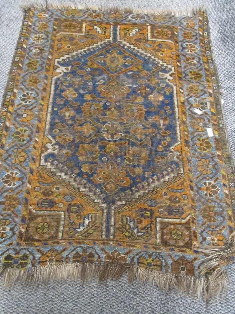 An Antique Persian or Caucasian woven wool rug or prayer mat, 110cm by 82cm.