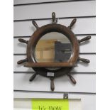 A mid century stained wood nautical mirror with shelf, in the form of a ships wheel.