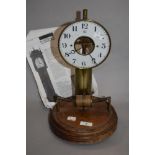 An early 20th Century French Bulle electric clock, the large brass column supporting an enamelled