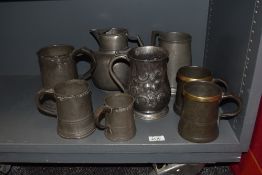 A mixed lot of antique pewter tankards and a jug, some interesting designs and some with many