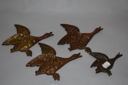 A group of four graduating cast metal flying geese ornaments, the largest measuring 19cm long