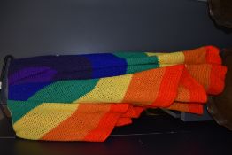 A crochet blanket of rainbow colours.