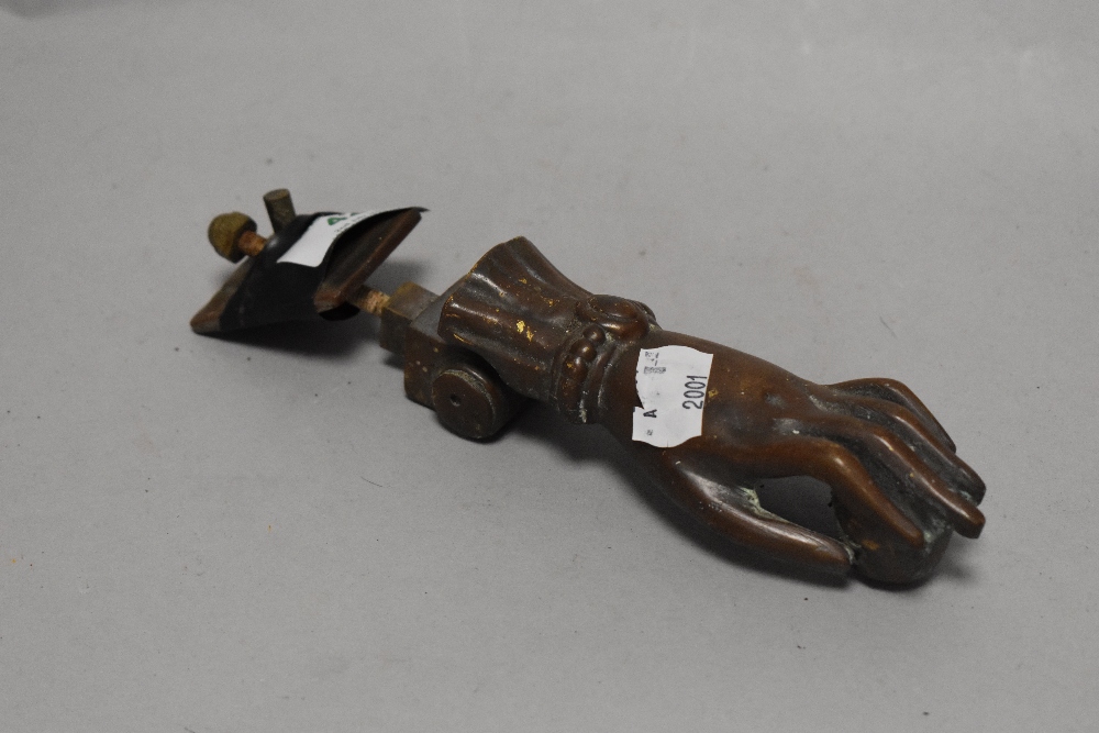 A novelty antique cast iron door knocker, modelled as a ball in hand, measuring 20cm long