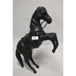 A vintage leather horse, having glass eyes and brass stirrups.