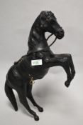 A vintage leather horse, having glass eyes and brass stirrups.
