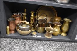 A shelf full of vintage brass and copper wares, pestle and mortar, bowls, candlesticks and more to