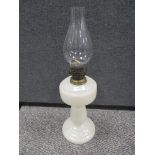 A vintage milk glass oil lamp with chimney.