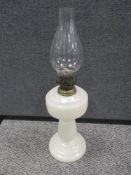 A vintage milk glass oil lamp with chimney.