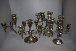 Three silver plated candelabras, the largest measuring 25cm tall and 46cm across