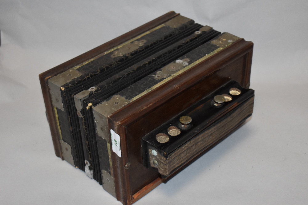 A 19th Century square concertina accordion, bearing a faded paper manufacturer's label, 26cm wide