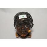 A novelty pottery tobacco jar, modelled as a Blackamoor smoking a pipe, 12cm tall
