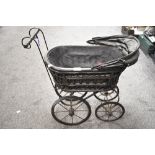 A vintage dolls pram of wood and metal.