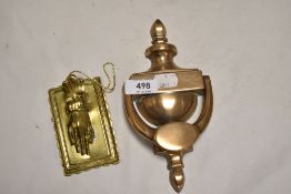 A cast brass door knocker and a brass memo holder in the form of a hand.