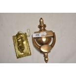 A cast brass door knocker and a brass memo holder in the form of a hand.