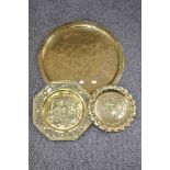 An antique Indian brass table top tray with two similar brass trays.