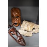 Two wooden tribal masks and a pottery shell study.