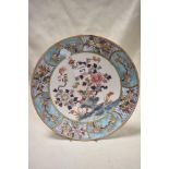 A Chinese enamelled porcelain plate, decorated with flora and fauna within a diaper and foliate