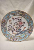 A Chinese enamelled porcelain plate, decorated with flora and fauna within a diaper and foliate