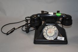 An early plastic rotary dial telephone.