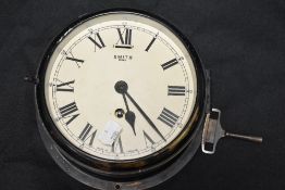 A Smiths 8-Day bulkhead clock, the brass case patinated/painted, sold with key 20cm diameter