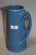 A mid century moulded jug, having blue glaze with dragon decoration to handle.