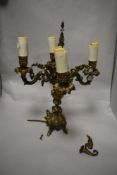 A cast metal four branch table lamp in the form of an antique candleabra, having gilt finish.