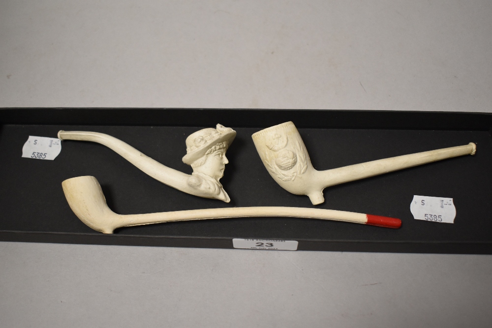 Three antique clay pipes, including novelty pipe depicting ladies head.