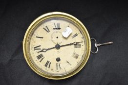 An early 20th century brass ship's bulkhead clock, having bevelled glass door and cream painted