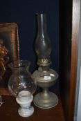 An early 20th century table top oil lamp with chimney and a marble based candle holder with shade.