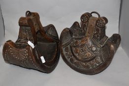 A pair of highly decorative South American carved wooden stirrups.