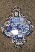 An early 20th Century blue and white Delftware wall plaque, of shield form, with hand painted