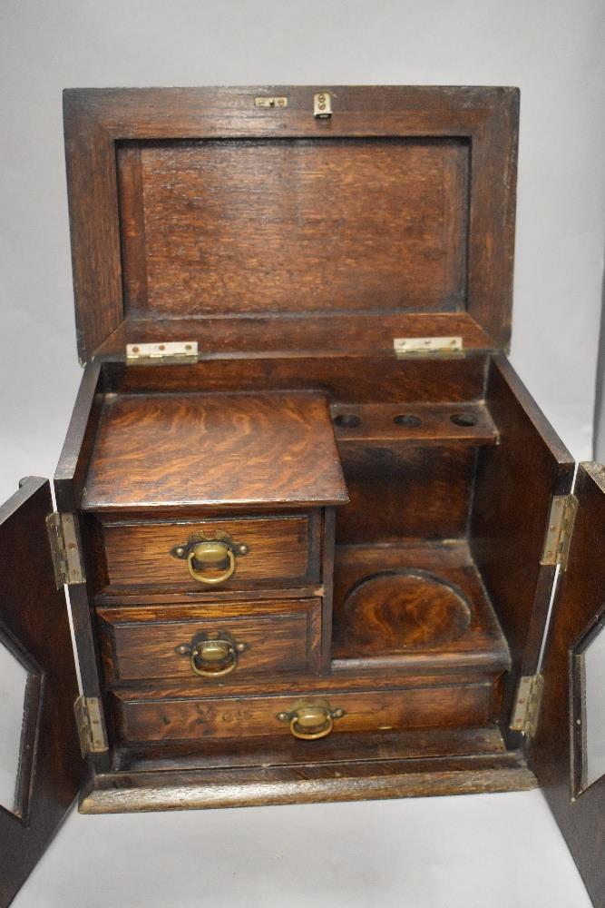 An early 20th century oak smokers cabinet, having two doors with diamond shaped glass and beaded - Image 2 of 2